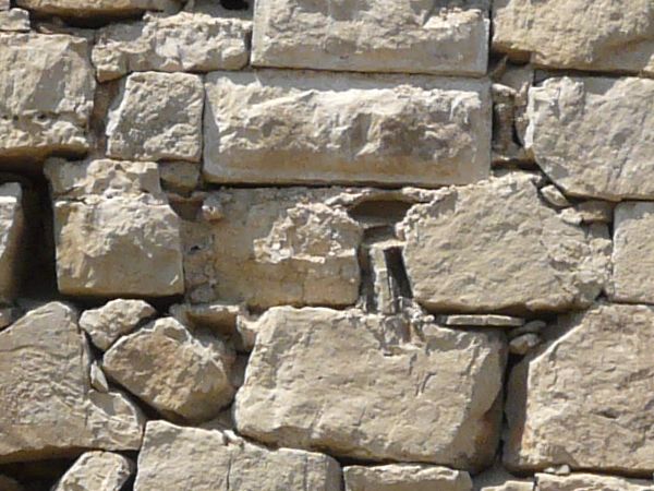 Seamless texture of medieval stone wall consisting of grey stones of various shapes and sizes.