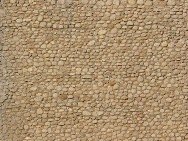 Texture of small, round stones set evenly in brown concrete.