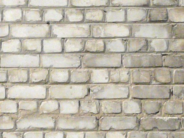 Brick wall with natural brown color on bottom portion and painted white on larger top portion.