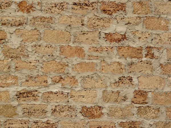 Brick wall with rough surface and thick grey cement.