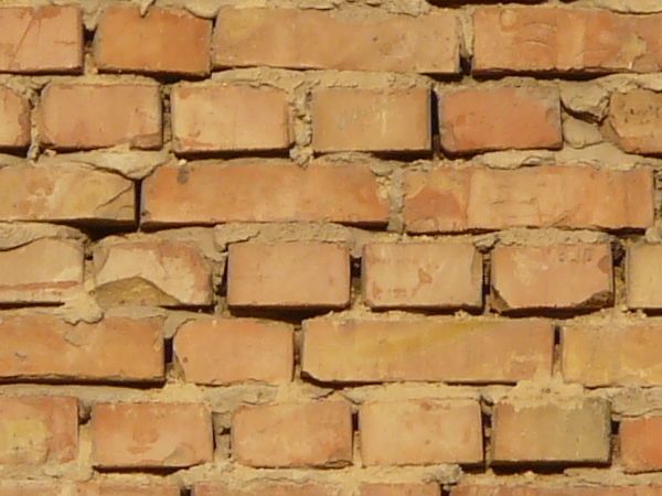 Brick wall in light brown color with thick brown concrete.