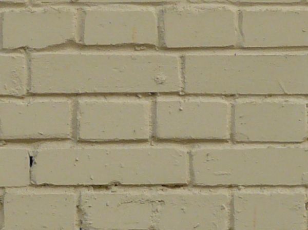 Modern brick wall laid evenly and painted over in off-white color.