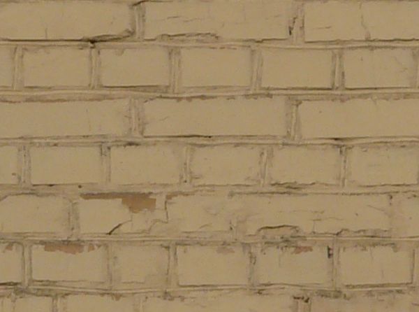 Brick wall laid evenly and painted over in beige color.