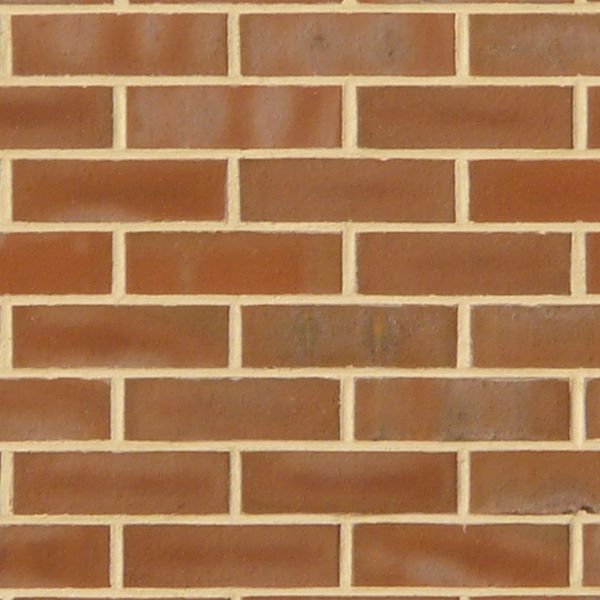 New red brick set in beige cement with faded white spots.