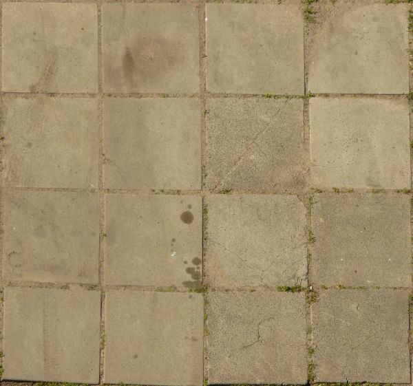 Seamless texture of square tiles in grey color with worn, stained surface and some vegetation.