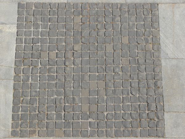 Seamless pavement texture containing small, square tiles in grey tone set evenly in grey cement.