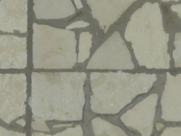 Seamless pavement texture consisting of square tiles made of random pieces of grey slate.