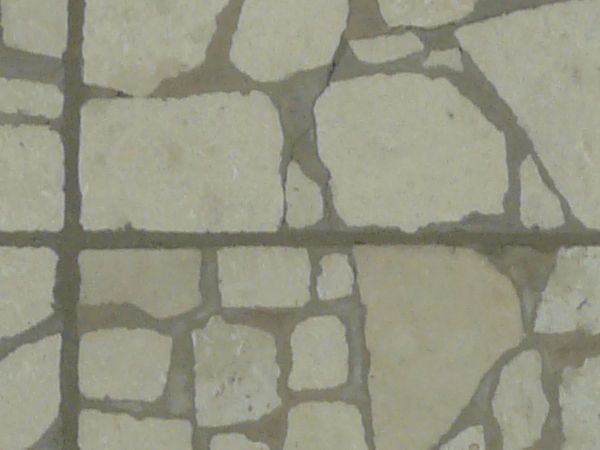 Seamless pavement texture consisting of square tiles made of random pieces of grey slate.