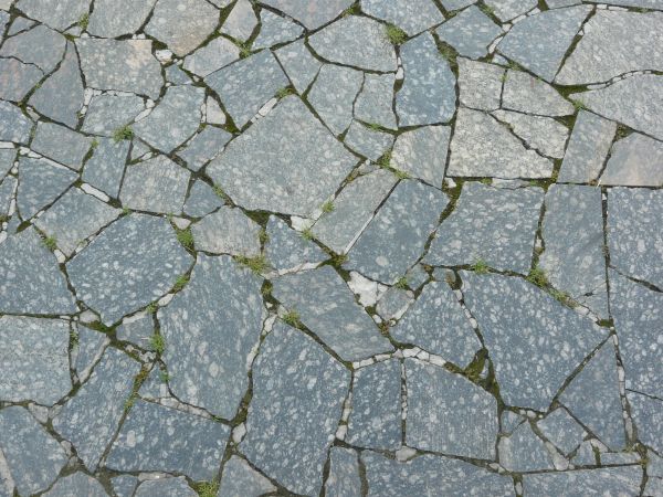 Pavement made of broken stone tile pieces and installed in crazy formation.