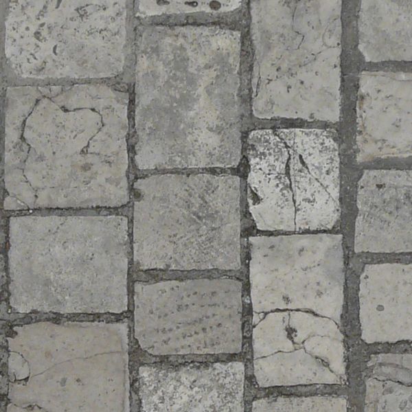Seamless pavement texture consisting of grey stones of various shapes with worn surface.