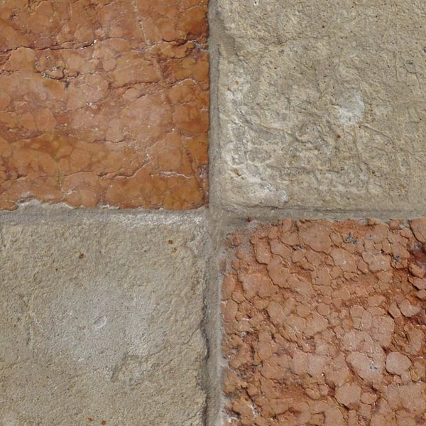 Seamless texture of beige and red, square blocks set evenly with some damage on surface.