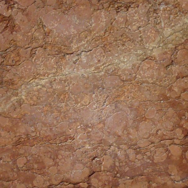Seamless texture of beige and red, square blocks set evenly with some damage on surface.