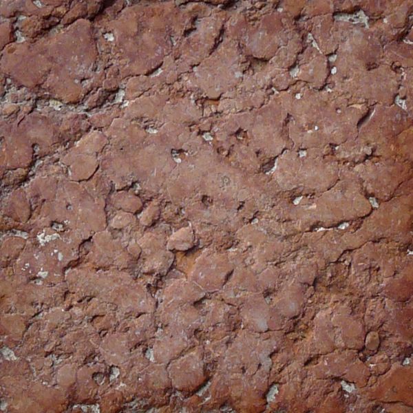 Seamless texture of beige and red, square blocks set evenly with some damage on surface.