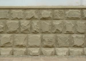 Jutting-out stone set in wall in beige tone.