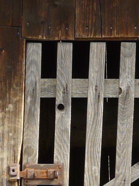 Texture of small shed made of wood with roof made of angled, wooden shingles.