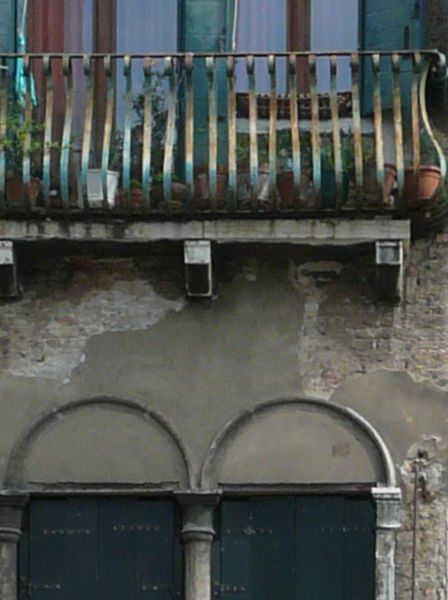 Very old, irregular building of worn concrete and old, wooden windows.