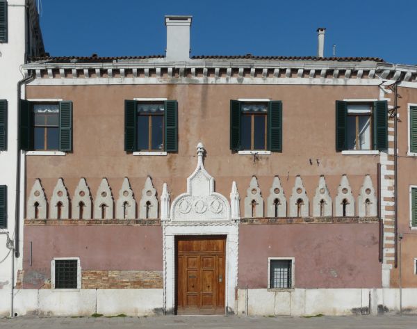 Texture of old building with worn surface and intricately designed trims and frames.