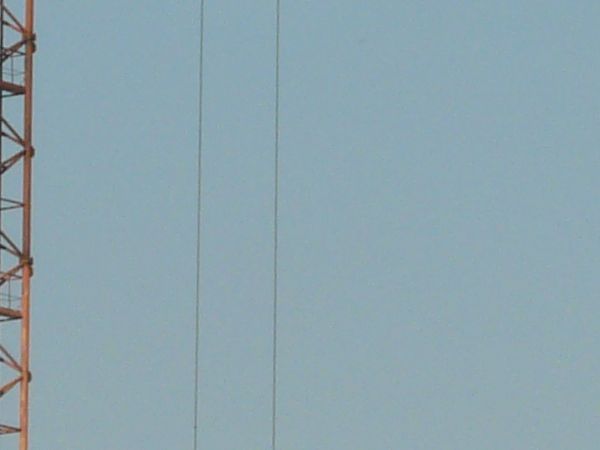 Red crane texture, made up of a lattice of painted steel beams. Pieces of two other yellow cranes are also visible.