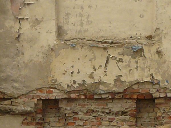 Damaged ruins of concrete building with very worn, damaged surface.