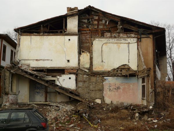 Ruins of large, old building of brick, wood and concrete with very decrepit, damaged consistency.