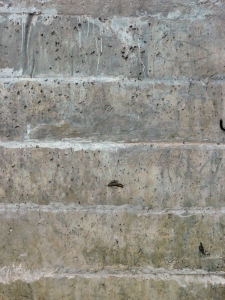 Concrete base in grey color with holes and filled-in seams.