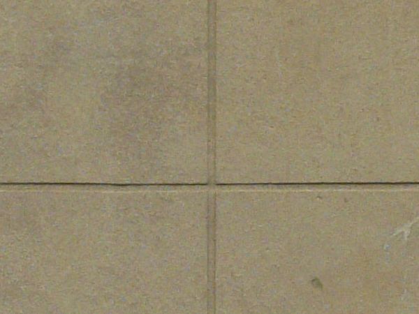 Concrete texture of rectangular blocks in beige color set evenly with slightly dirty surface.