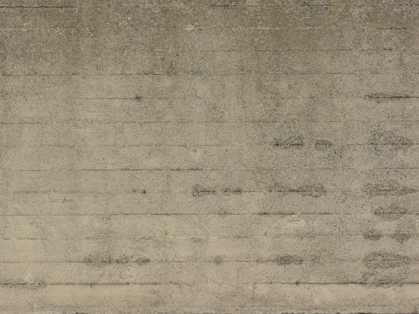 Texture of rough concrete in light beige tone with even, horizontal lines across surface.