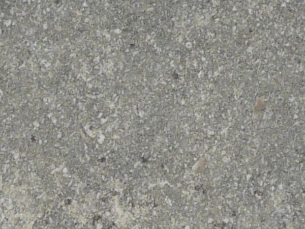 Concrete texture in grey tone with slightly rough surface and light spots.