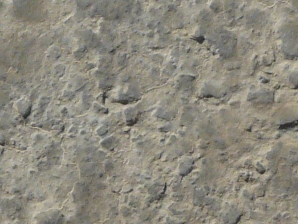 Texture of concrete in grey tones with rough, irregular surface.