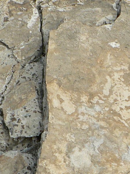 Texture of large, concrete slab with very rough, crumbling surface.