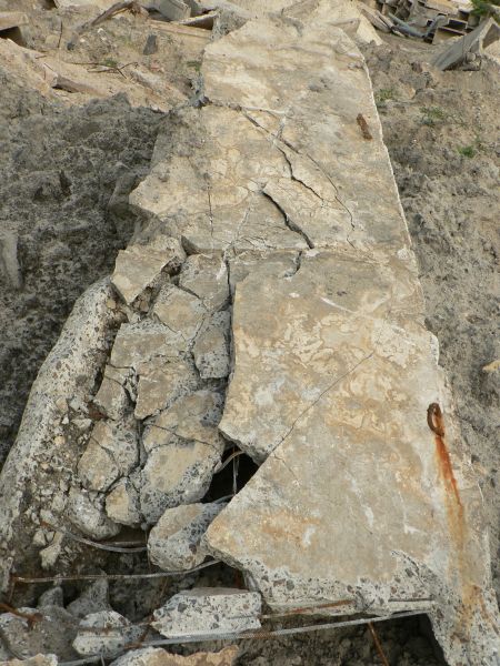 Texture of large, concrete slab with very rough, crumbling surface.