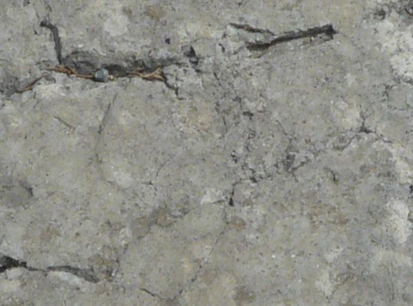 Rectangular concrete slab with large cracks throughout surface.
