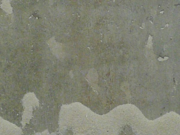 Concrete ground texture in light grey tone with smooth surface and light beige spots.