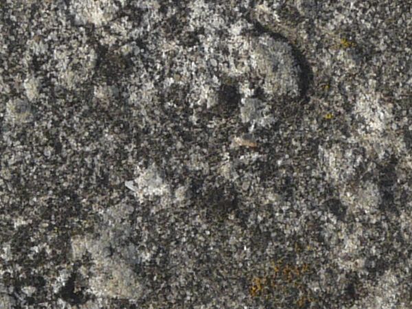 Concrete ground texture in dark grey tone with very rough, damaged surface.