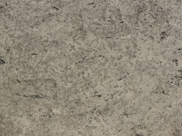 Texture consisting of concrete in light grey tone with very rough, irregular surface.