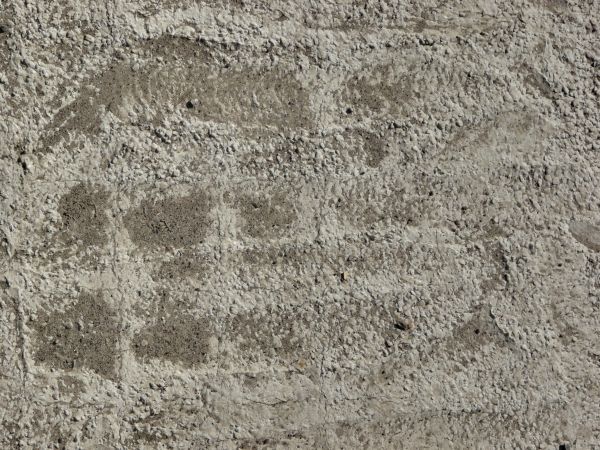 Concrete ground texture in light grey tone with rough surface and dirt.