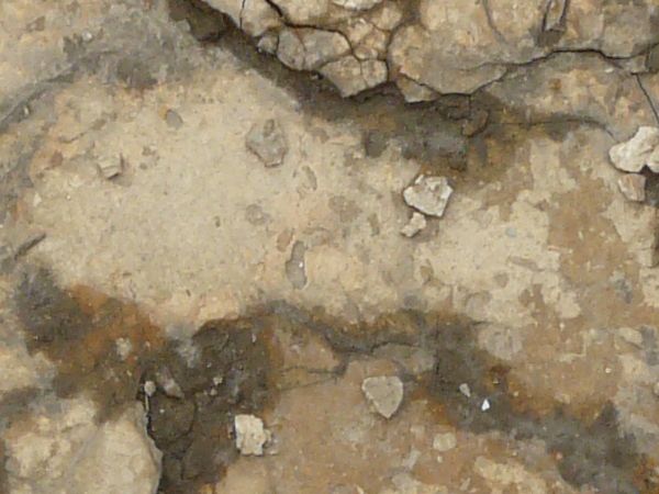 Ground of beige concrete with extremely damaged, crumbling consistency.