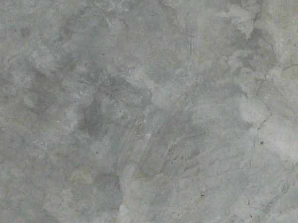 Smooth concrete floor texture in patches of different tones of grey.
