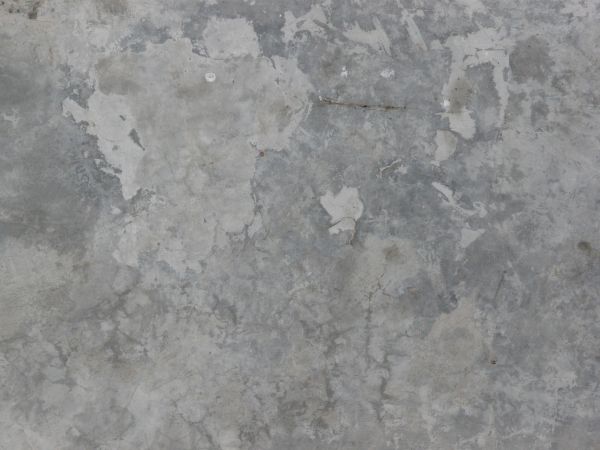 Smooth concrete floor texture in patches of different tones of grey.