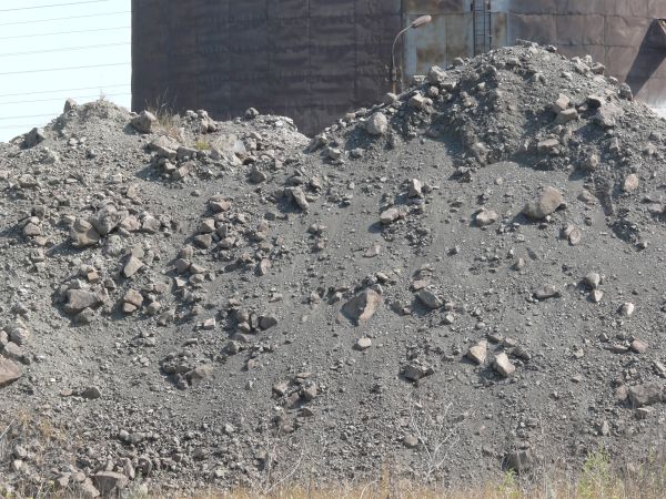 Rocky grey slope texture covered with grey and red rocks of various shapes and sizes.