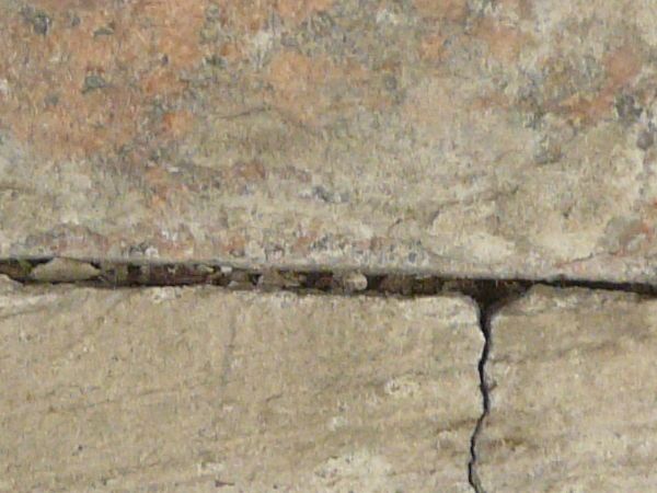 Concrete texture with very rough surface and cracked, crumbling surface.