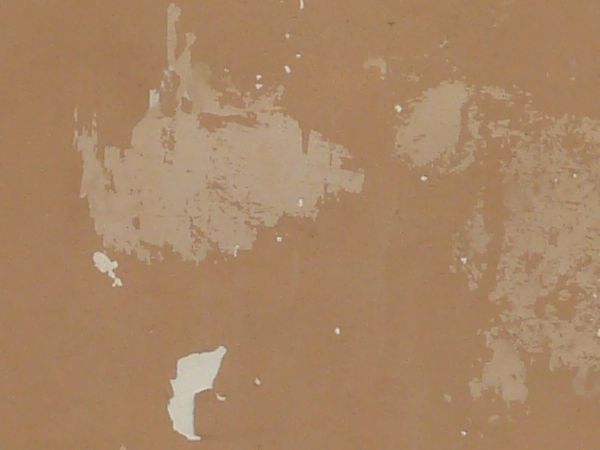 Solid surface covered in thin layer of pealing, brown paint.