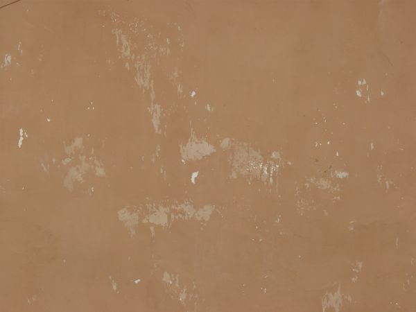 Solid surface covered in thin layer of pealing, brown paint.