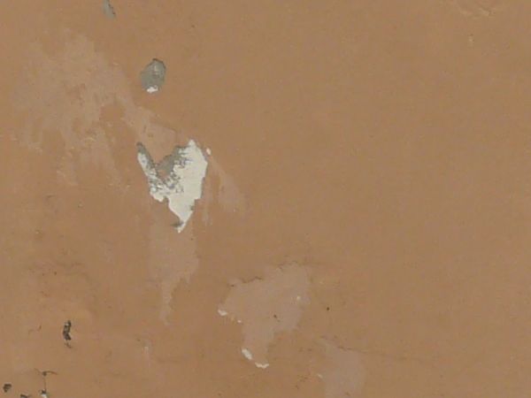 Solid surface covered in thin layer of pealing, brown paint.