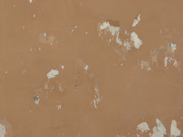 Solid surface covered in thin layer of pealing, brown paint.