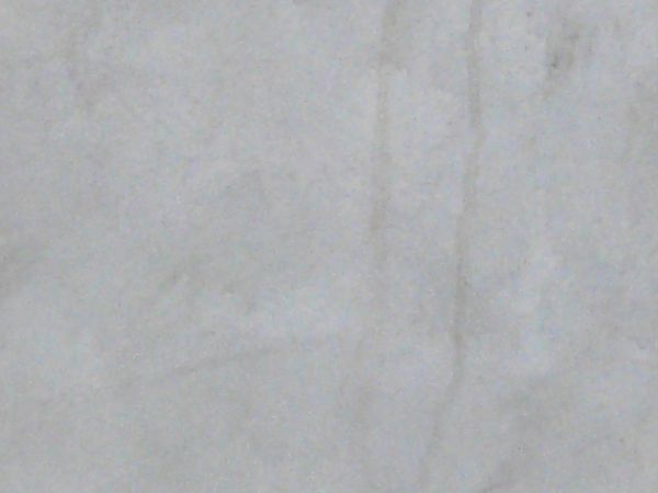 Texture of smooth surface in white tone with thin, brown streaks coming from top.