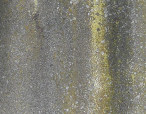 Solid material in irregular, grey color with yellow streaks on surface.