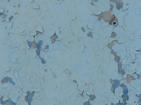 Worn metal surface with peeling blue paint.