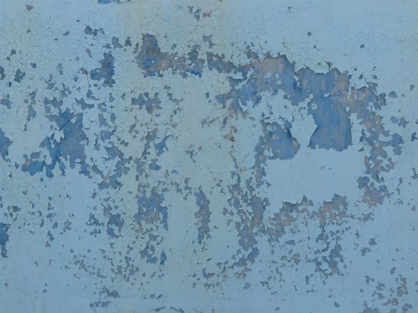 Worn metal surface with peeling blue paint.