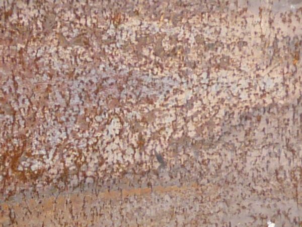Old metal texture in bronze tone with traces of rust on surface.